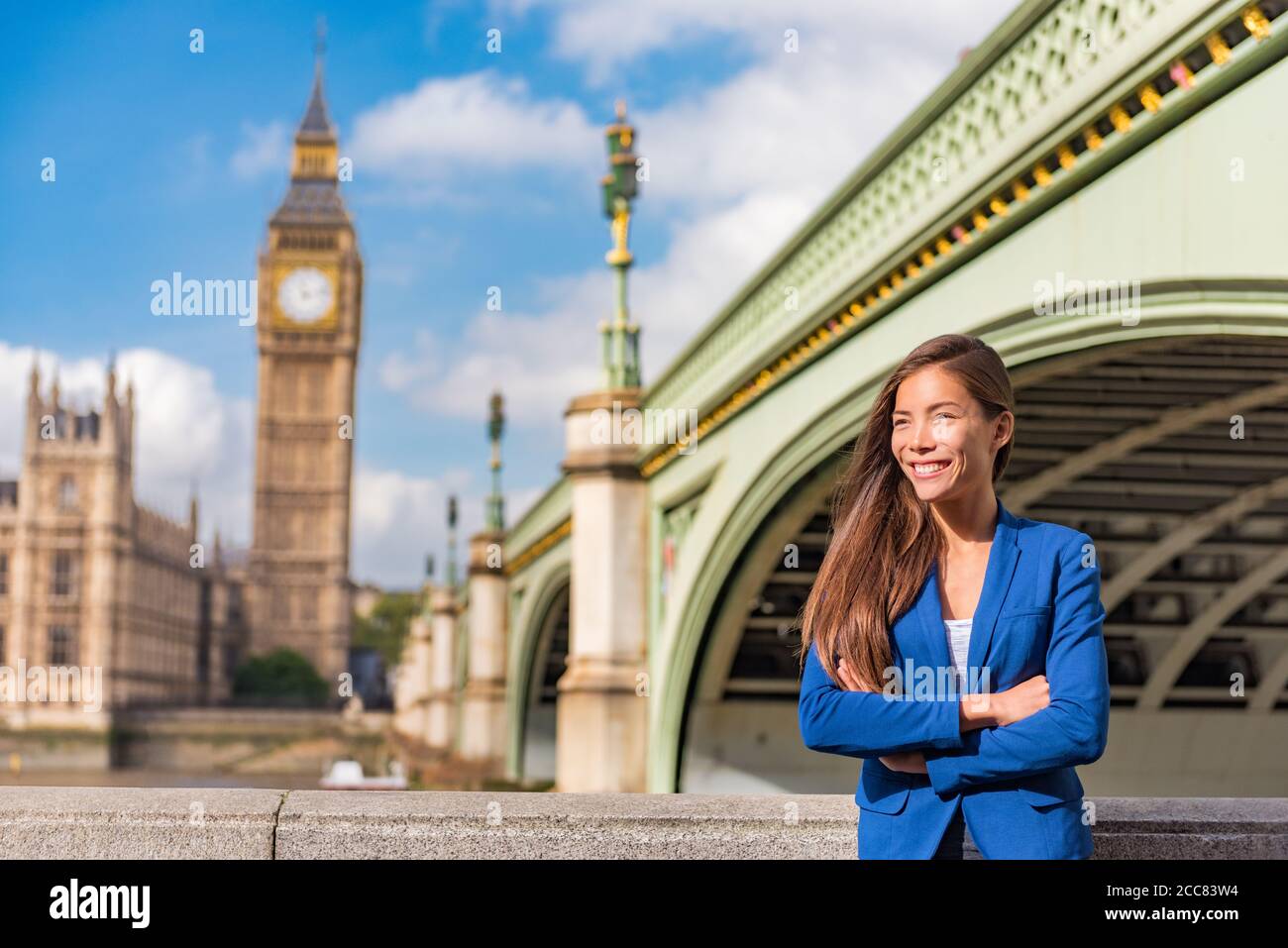 Ritratto della donna di affari di Londra. Stile di vita urbano. Donna d'affari asiatica felice sorridente guardando verso Big ben, Westminster, Londra, Regno Unito Foto Stock