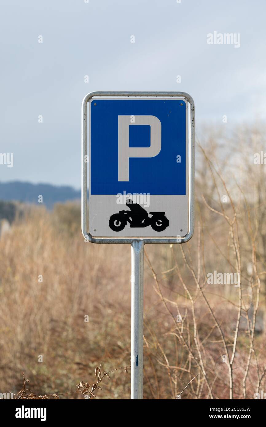 cartello blu per il parcheggio delle moto con scritta bianca e motocicletta nera Con una grande "P" su sfondo blu Foto Stock