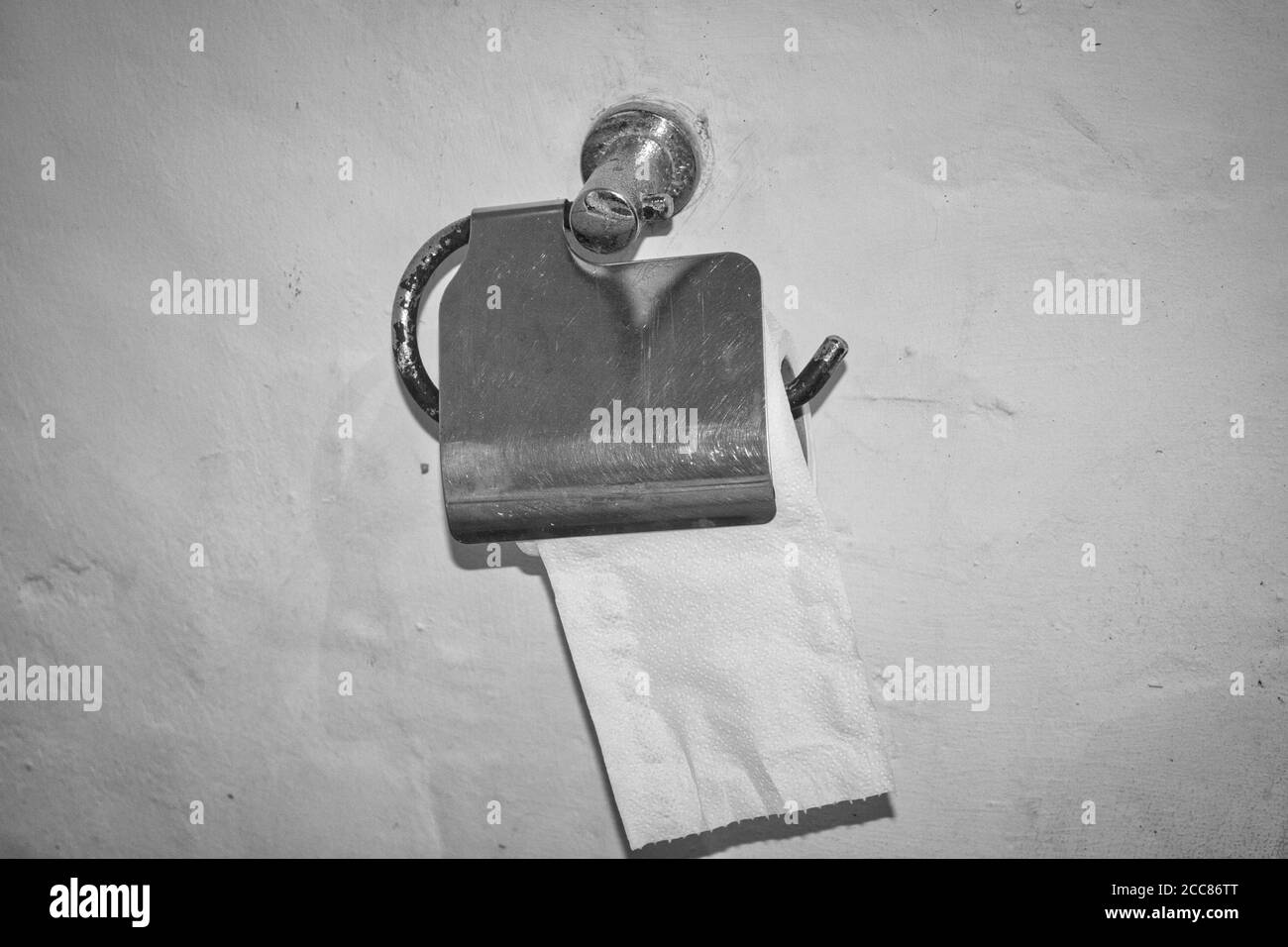 Questa foto unica mostra una fotografia in bianco e nero di un supporto per  carta igienica in acciaio inox fissato a. una parete di pietra bianca Foto  stock - Alamy