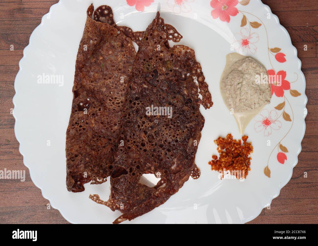 Ragi dose o Dosa, fatta con finger millet, colazione dell'India del Sud, servita con chutney di cocco Foto Stock