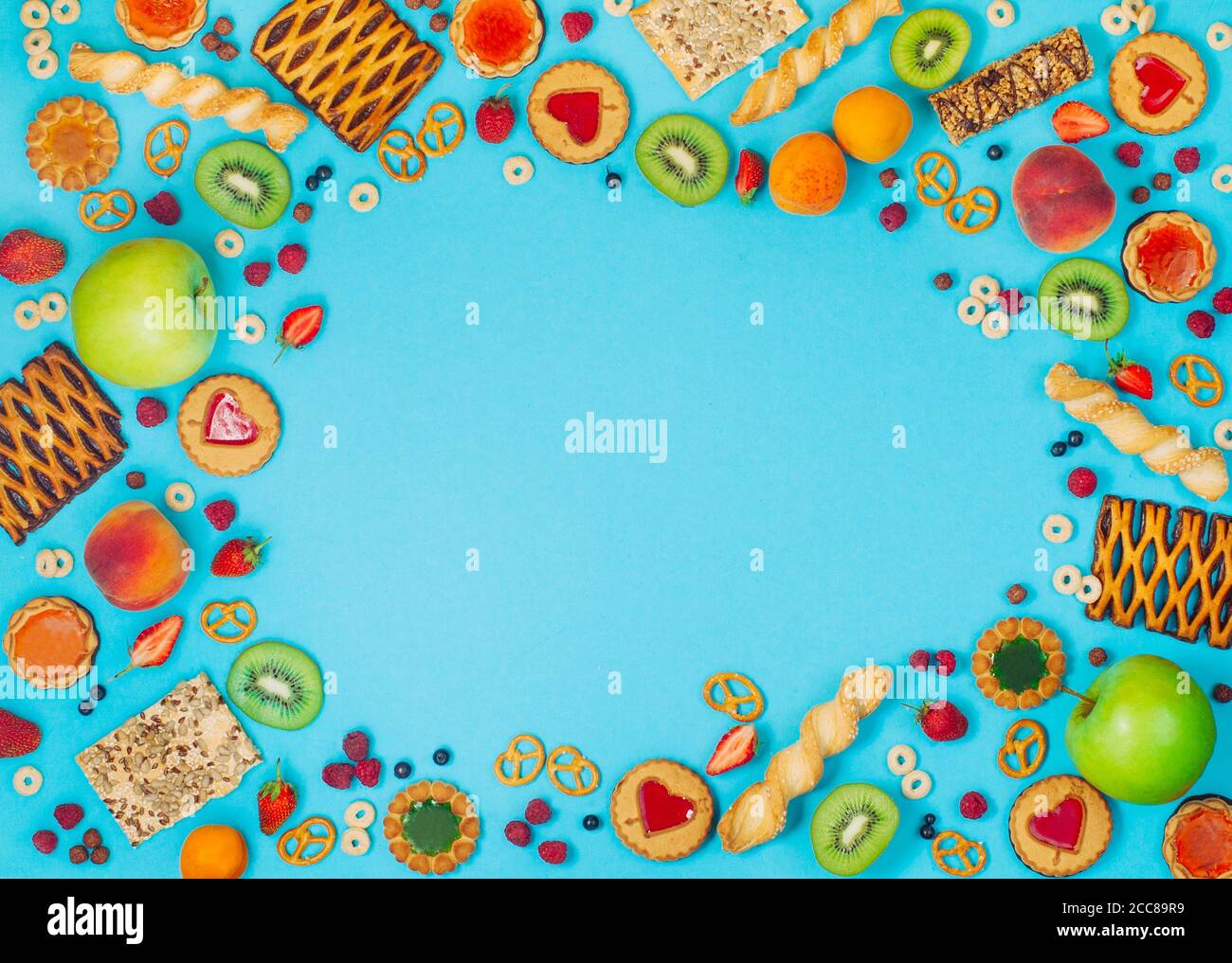 Cornice con un sacco di frutta, frutti di bosco e grappoli su sfondo blu Foto Stock