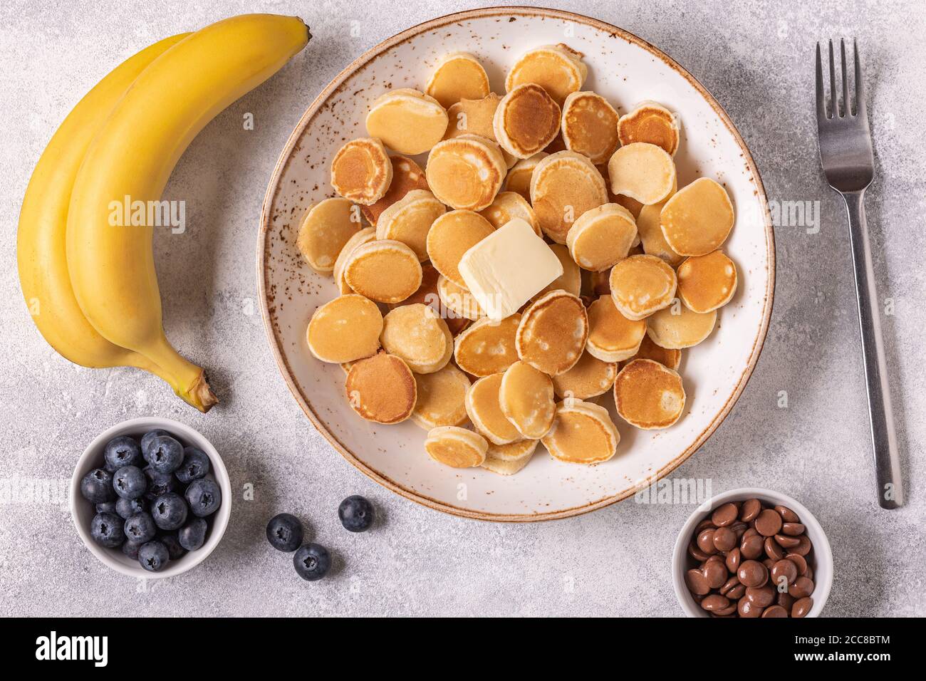 Colazione alla moda con mini pancake e burro, vista dall'alto. Foto Stock