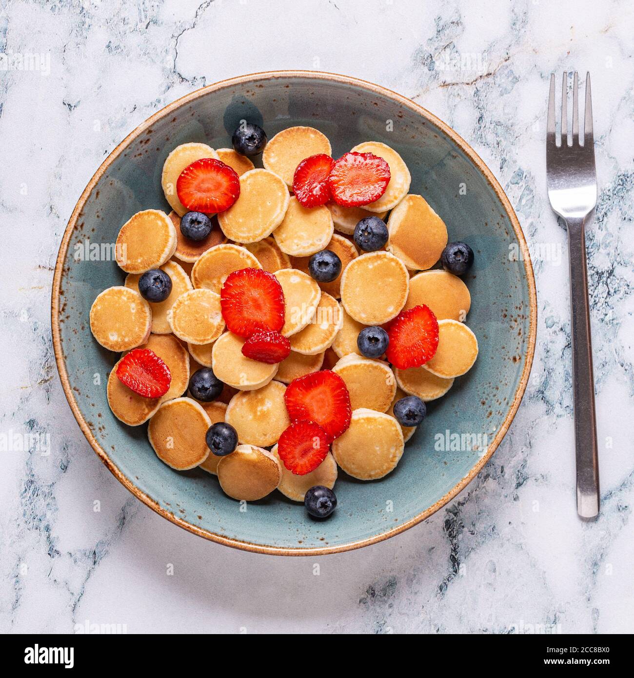 Colazione alla moda con mini pancake, mirtilli e fragole, vista dall'alto. Foto Stock