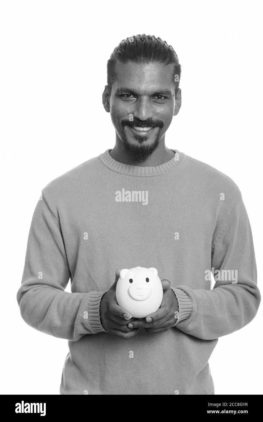 Giovani felici uomo indiano holding salvadanaio Foto Stock