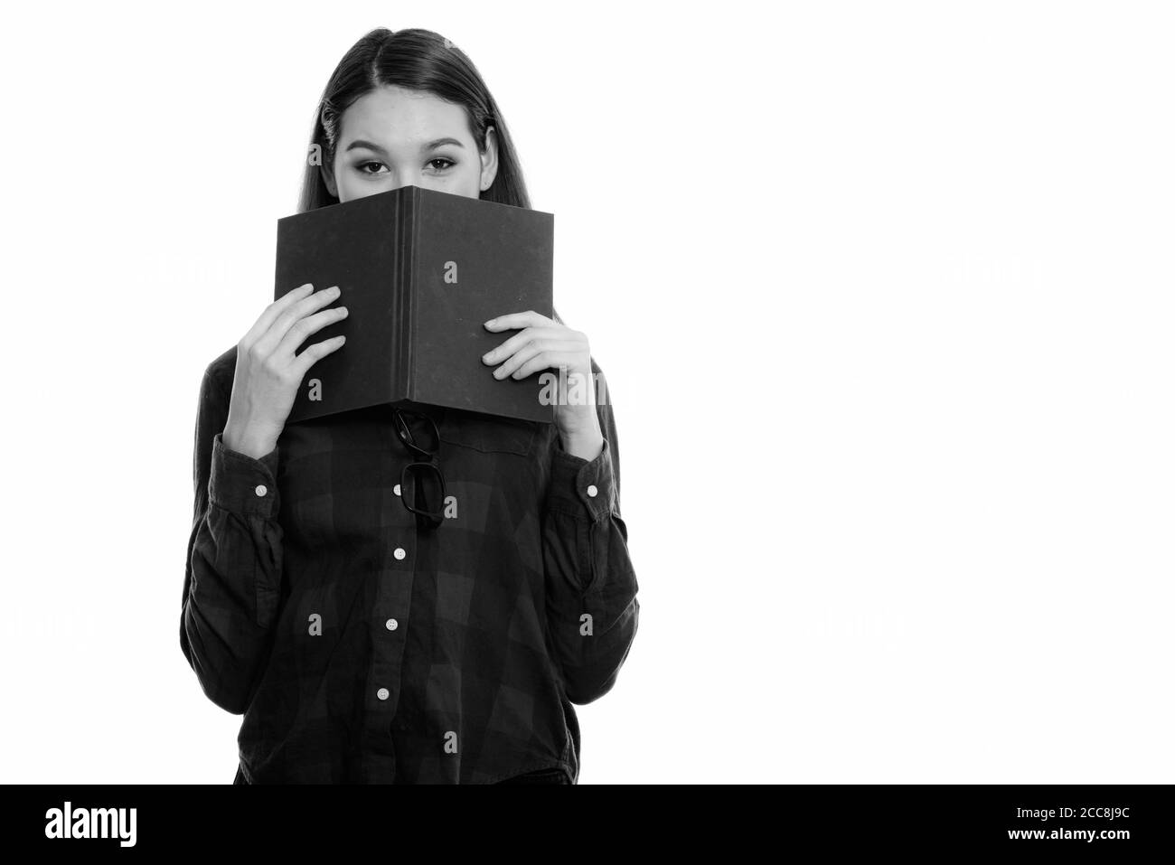 Studio shot del giovane bella donna asiatica nascondendo dietro il pacco Foto Stock