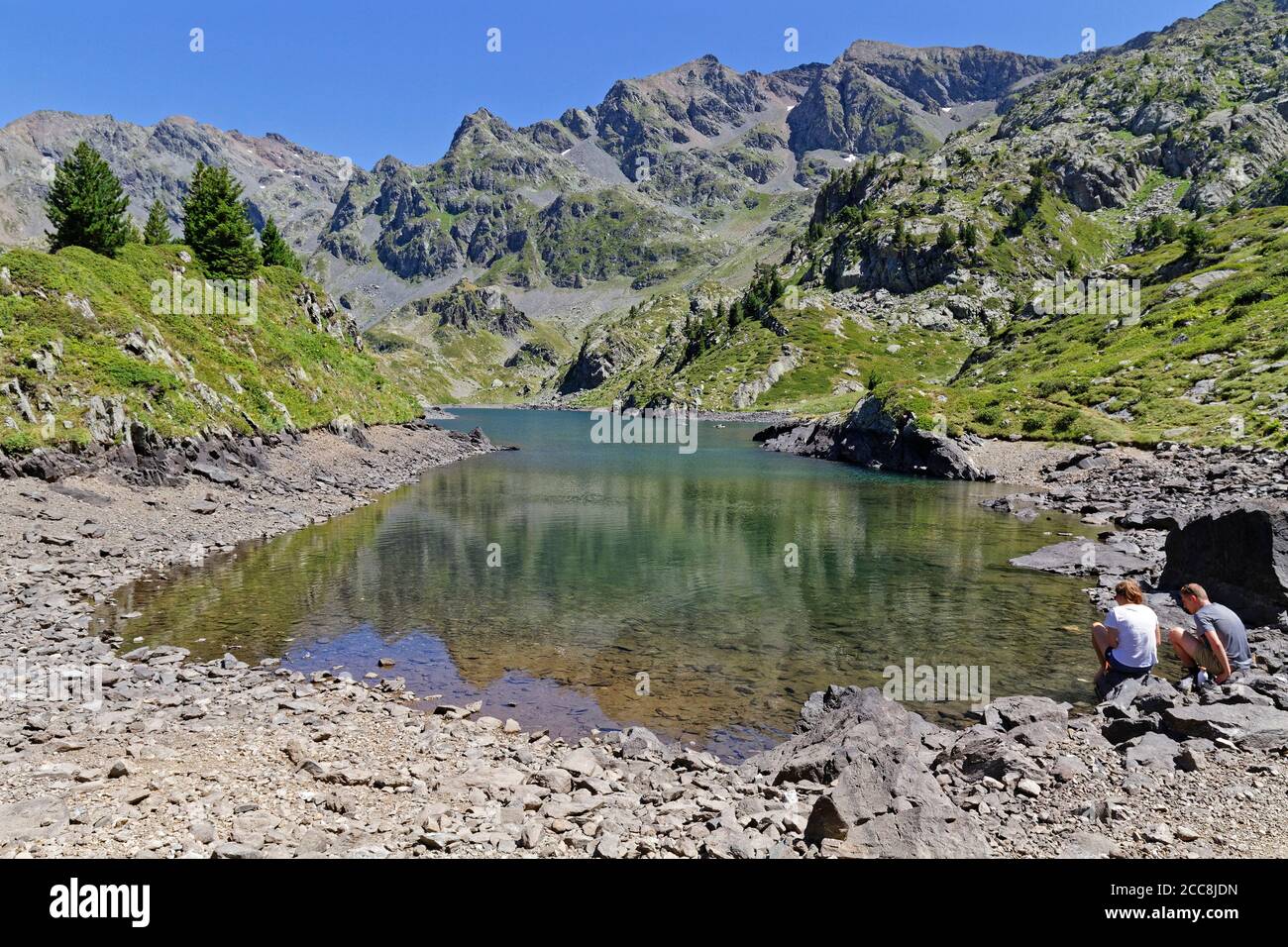 LA PRA, FRANCIA, 6 agosto 2020 : UNA giovane coppia di escursionisti riposano per un po' sul litorale di un bellissimo lago di montagna. Foto Stock