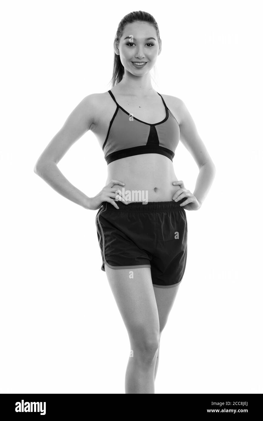 Studio shot di giovani felici bella donna asiatica sorridente e in posa pronti per la palestra Foto Stock