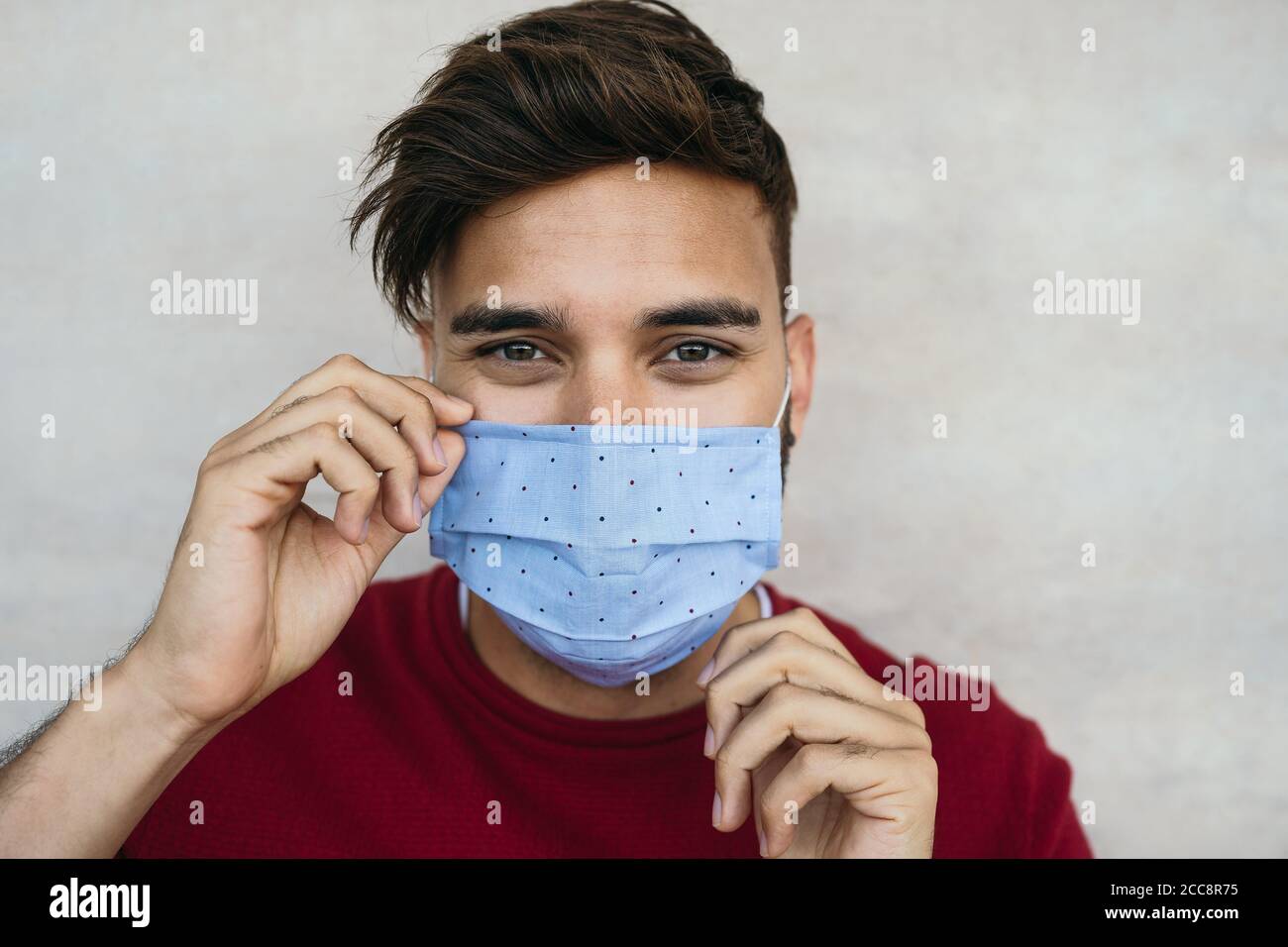 Giovane uomo che indossa maschera ritratto - ragazzo latino che usa maschera protettiva per prevenire la diffusione del virus corona Foto Stock