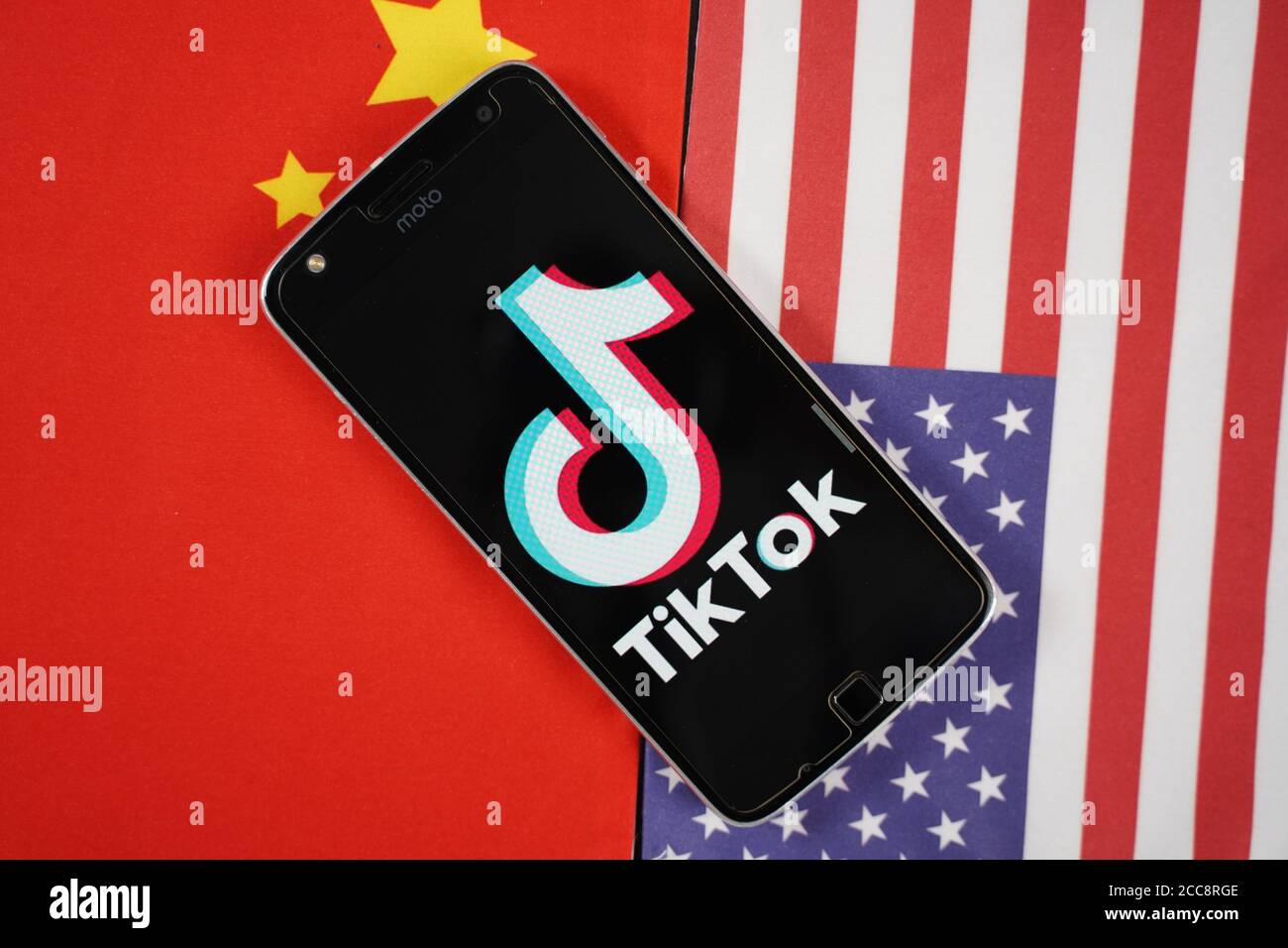 Maski, India 04, Agosto 2020 - il logo dell'app TikTok sullo schermo dello smartphone e posizionato sulle bandiere di Cina e Stati Uniti - l'app è al centro degli Stati Uniti - Cina Foto Stock