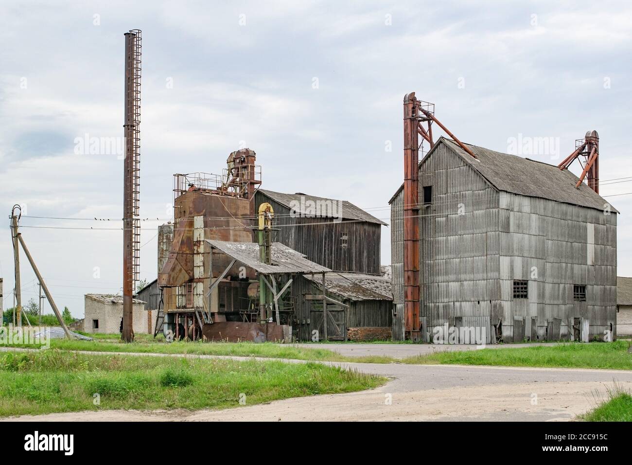 Vecchio essiccatore di grano sulla fattoria. Fattoria abbandonata con edifici industriali Foto Stock