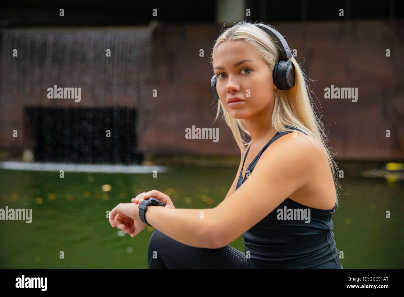 Montare la runner femminile utilizzando l'orologio intelligente per monitorare le sue prestazioni. Foto Stock