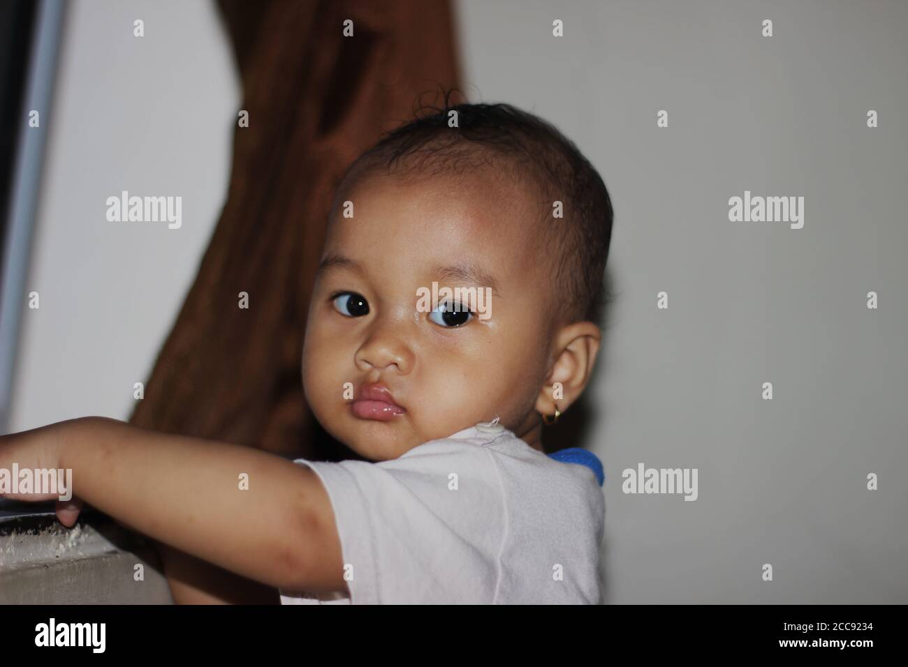 Una bella bambina indonesiana che gioca in casa Foto Stock