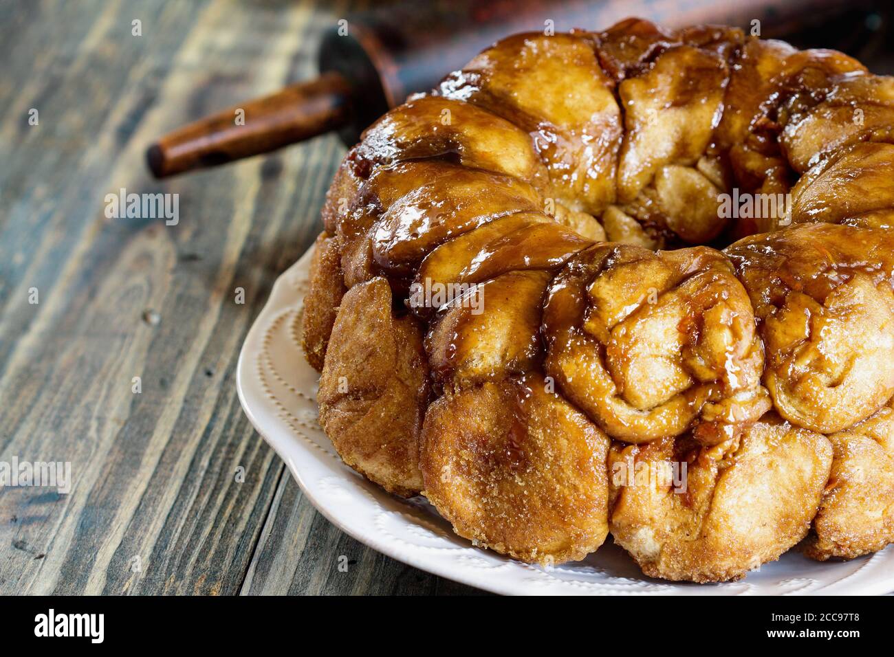 Dessert di Pull Apart Carota torta Monkey pane. Una torta di lievito a pezzetti fatta con cannella, carote, noci e uno smalto di zucchero di canna. Messa a fuoco selettiva con blu Foto Stock