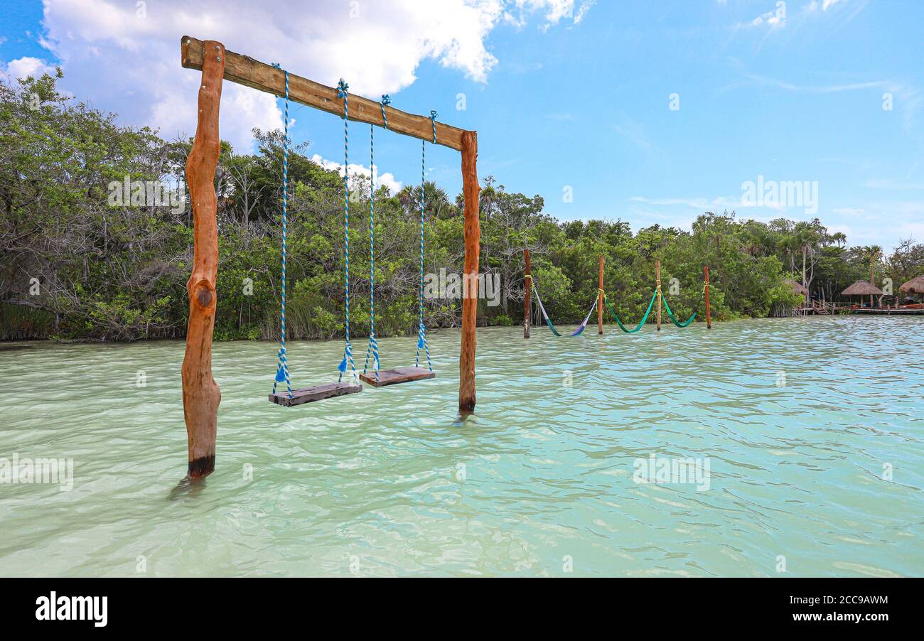 TULUM, QUINTANA ROO, MESSICO - 29 agosto 2019: Un set di altalene si trova in una splendida posizione nelle acque blu della laguna di Kaan Luum in Messico. Foto Stock