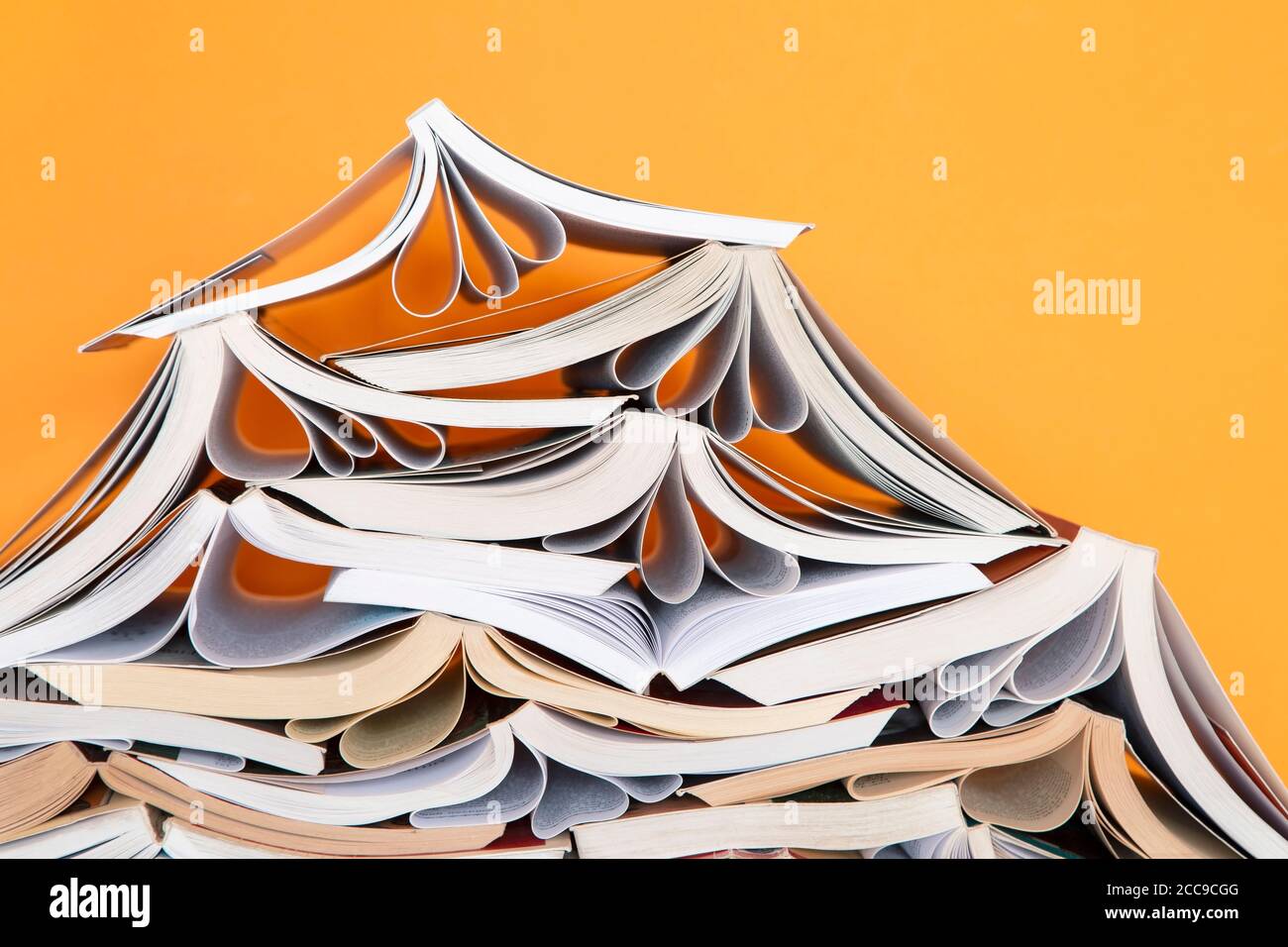 Pila di libri su sfondo giallo Foto Stock
