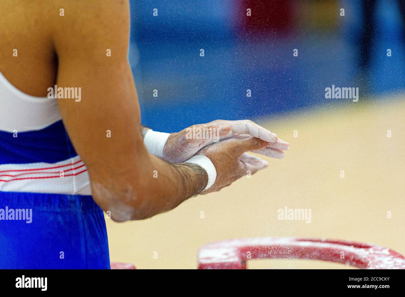 Ginnastica della nazionale francese utilizzando gesso per asciugare Le mani durante un evento di ginnastica artistica maschile Foto Stock