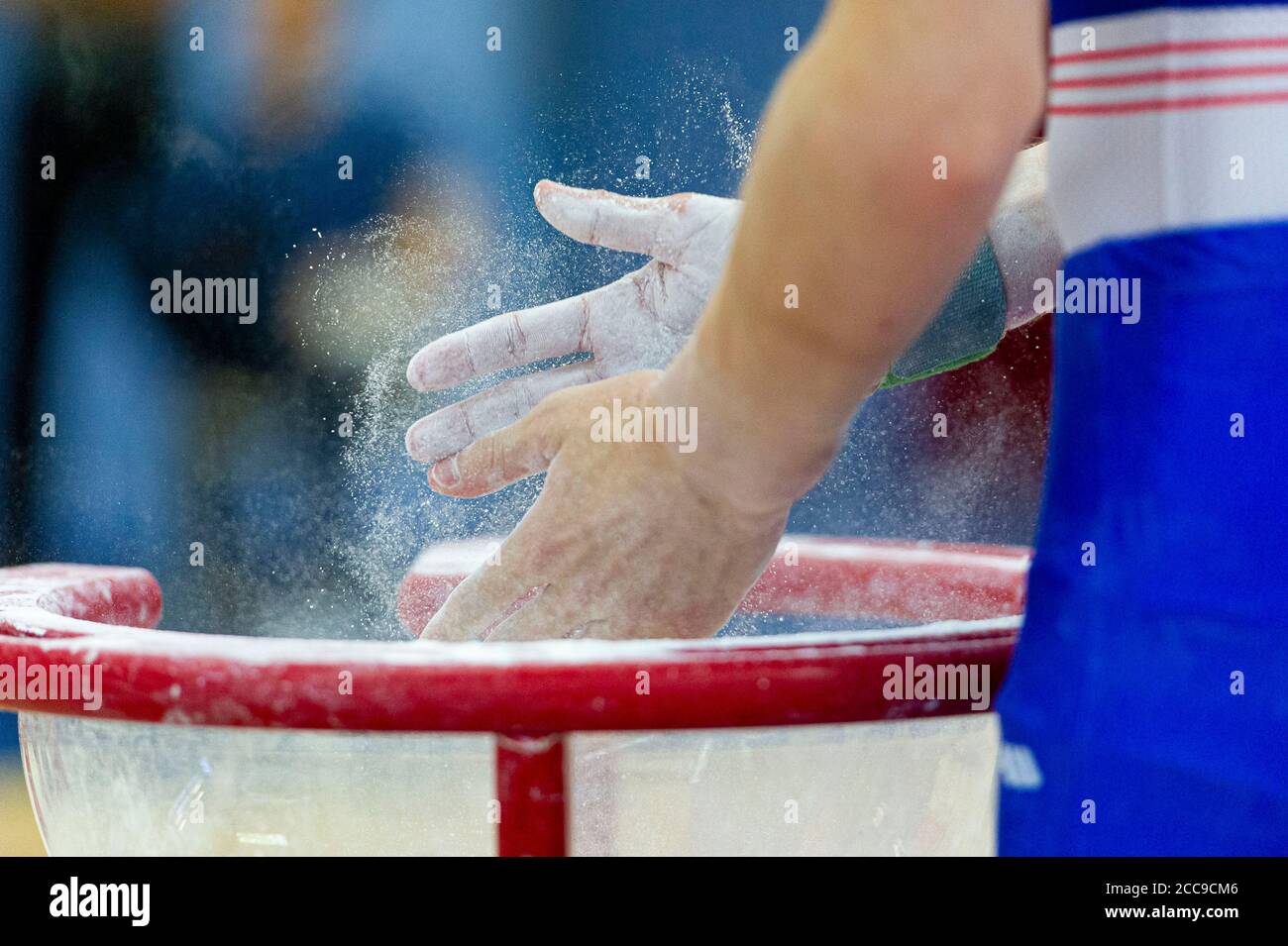 Ginnastica della nazionale francese utilizzando gesso per asciugare Le mani durante un evento di ginnastica artistica maschile Foto Stock