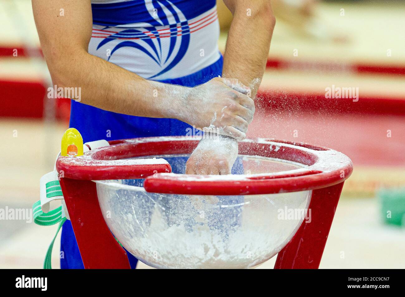 Ginnastica della nazionale francese utilizzando gesso per asciugare Le mani durante un evento di ginnastica artistica maschile Foto Stock