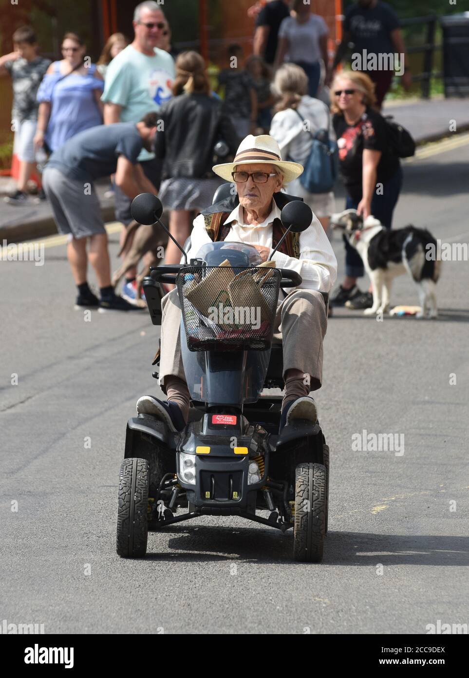 Anziano che guida il suo Pride Colt Executive Mobility Scooter in viaggio, Gran Bretagna, Regno Unito Foto Stock