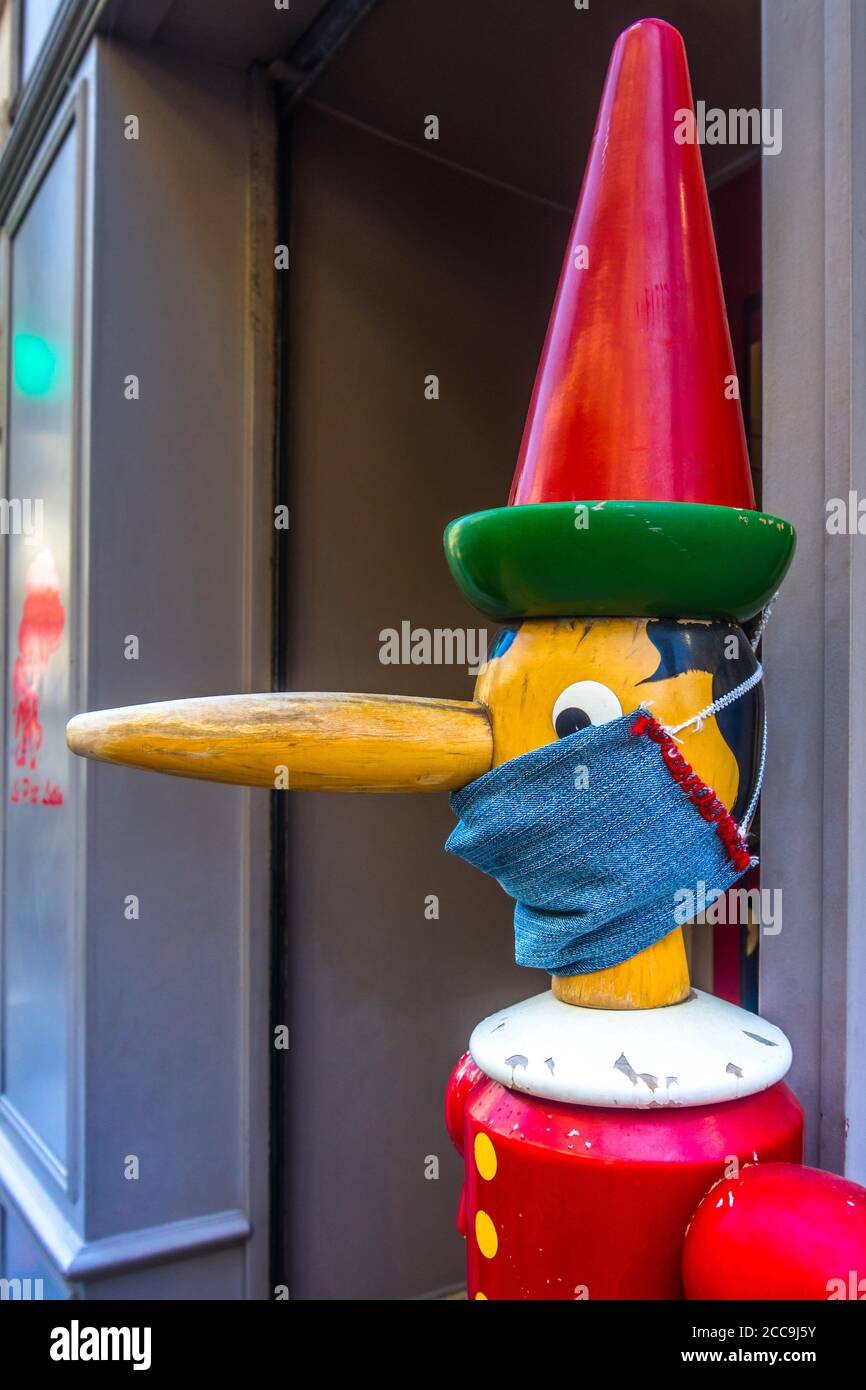 Personaggio di Pinocchio che indossa una maschera protettiva per il viso Covid-19 fuori dal negozio di giocattoli 'Jeu Jouet' ad Angers, Maine-et-Loire, Francia. Foto Stock