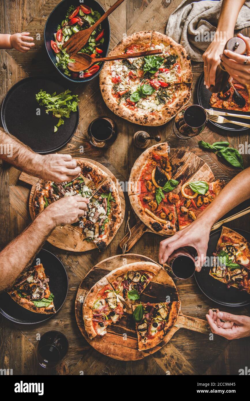 Cena con pizza in famiglia con vino rosso, vista dall'alto Foto Stock