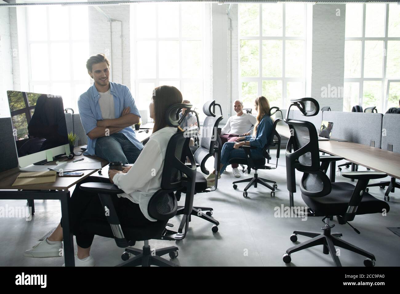 Vita in ufficio. Un gruppo di giovani uomini di affari di lavoro e  comunicare tra loro in ufficio creativo Foto stock - Alamy