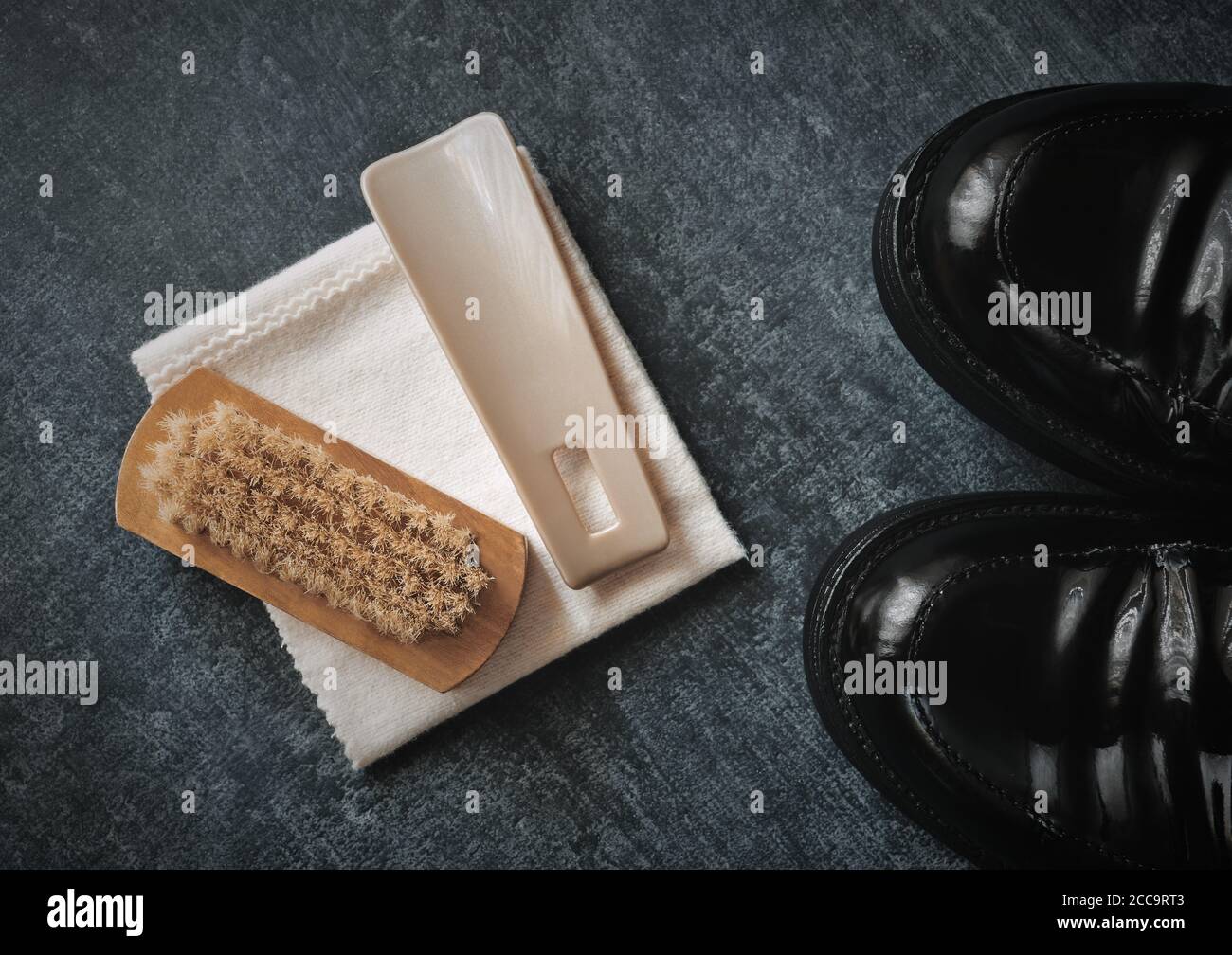 Set per la cura di scarpe e scarpe laccate nere, spazzola, cucchiaio per scarpe e panno per lucidatura, stilizzato Foto Stock