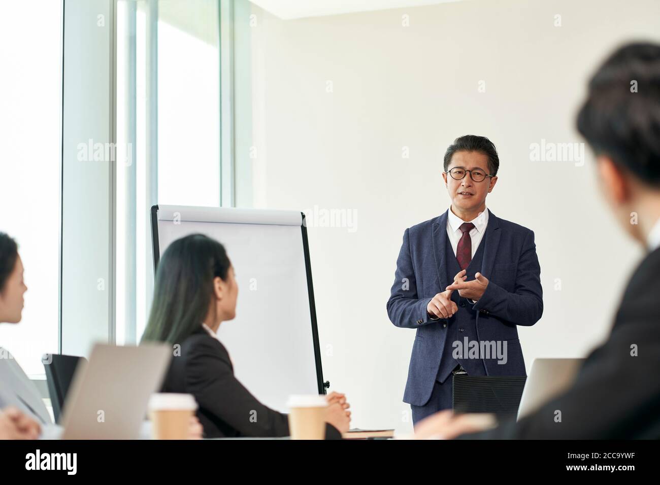 dirigente aziendale asiatico che facilita una discussione durante la riunione di gruppo in ufficio Foto Stock