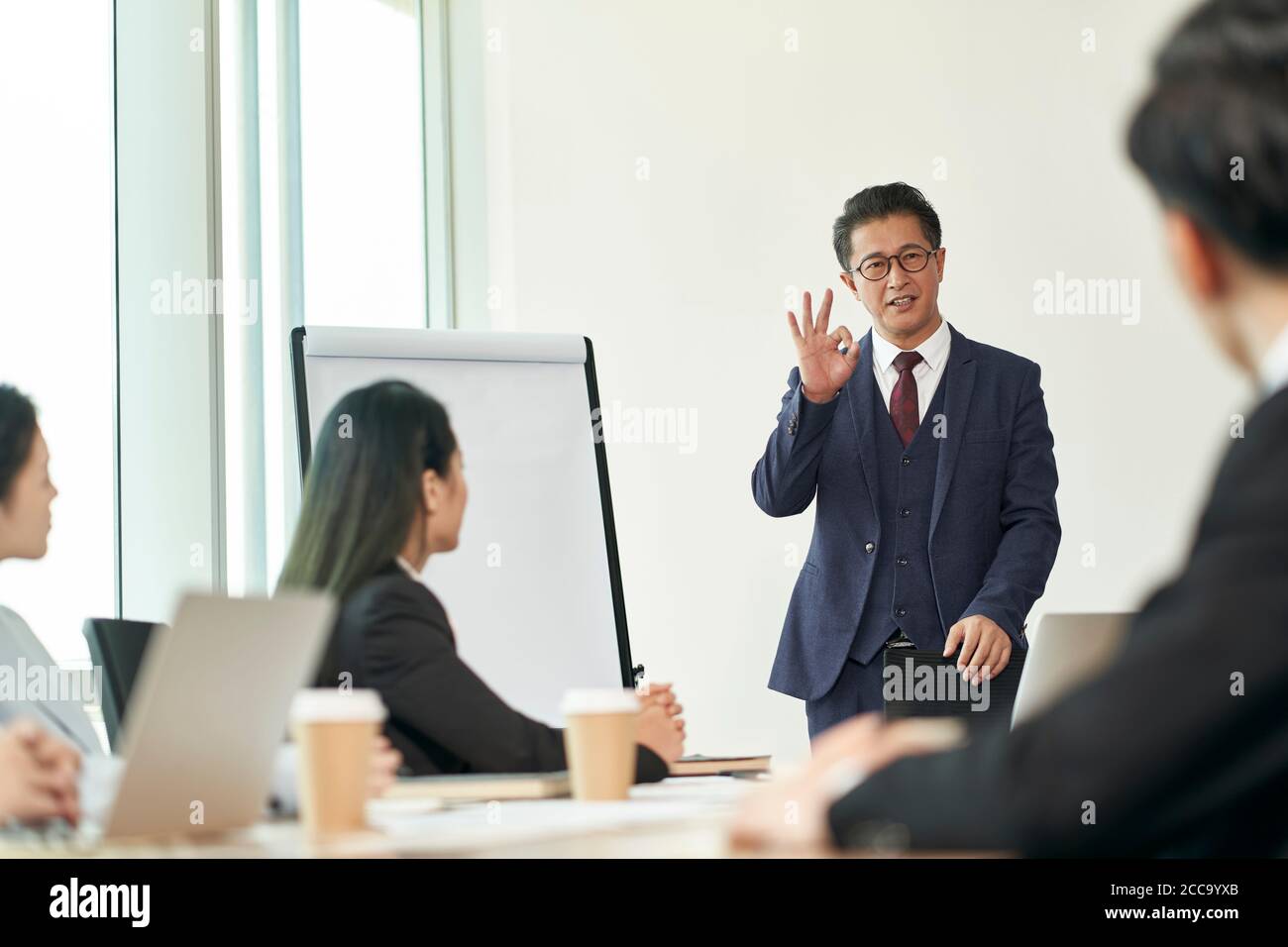 il dirigente aziendale asiatico ha tenuto un discorso durante la riunione di gruppo in ufficio Foto Stock