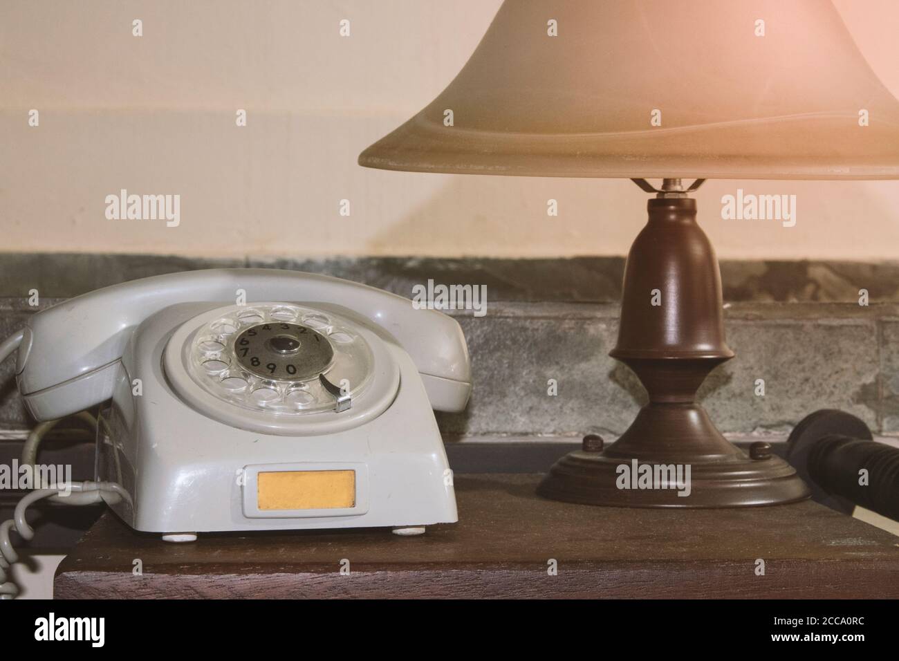 Vecchio telefono grigio e lampada retro sulla scrivania concetto immagine Foto Stock