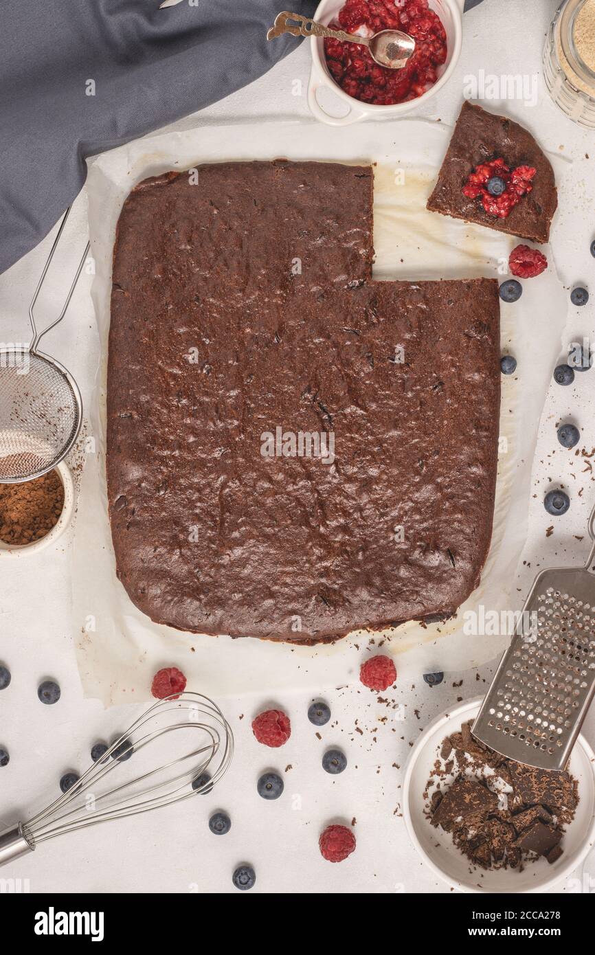 Brownie di cioccolato mediterraneo fatte in casa tagliate a pezzi con lampone e mirtillo posto su una carta pergamena. Foto Stock