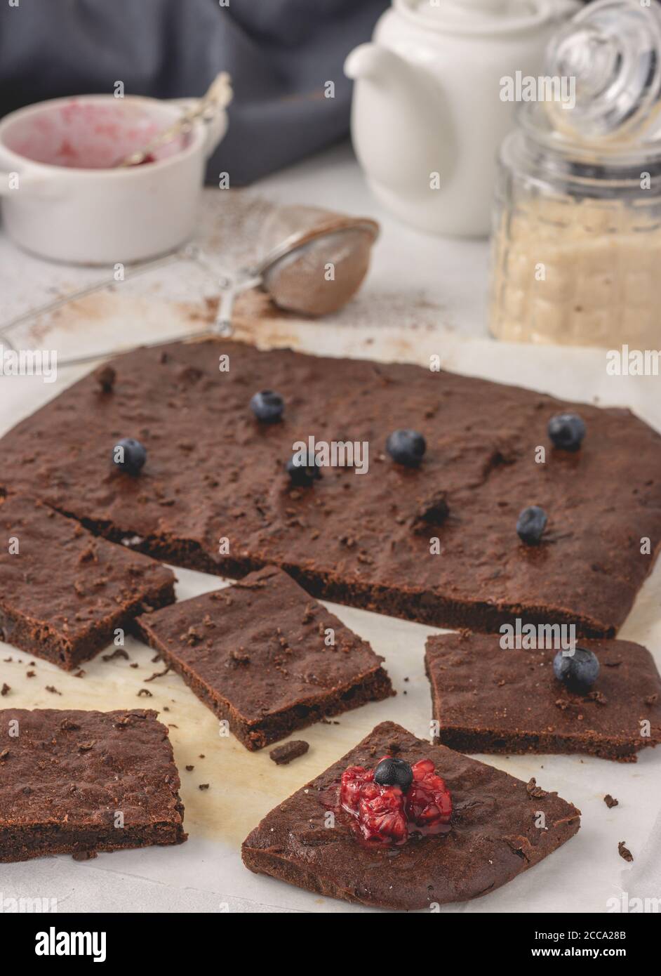 Brownie di cioccolato mediterraneo fatte in casa tagliate a pezzi con lampone e mirtillo posto su una carta pergamena. Foto Stock