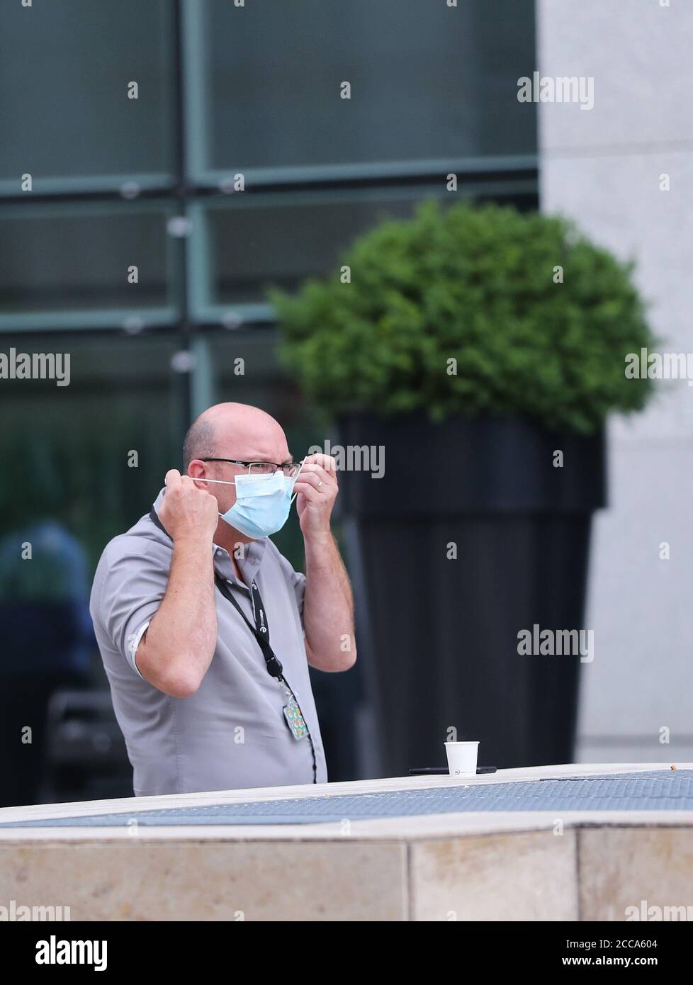 Parigi, Francia. 20 Agosto 2020. Un uomo toglie la sua maschera mentre si riposa fuori di un edificio di uffici nella zona commerciale la Defense vicino a Parigi, Francia, 20 agosto 2020. I lavoratori francesi dovrebbero indossare maschere in tutti i luoghi di lavoro collettivi come parte di un piano governativo per contenere un allarmante rimbalzo nelle infezioni da coronavirus, ha annunciato martedì il Ministro del lavoro Elisabeth Borne. Credit: Gao Jing/Xinhua/Alamy Live News Foto Stock