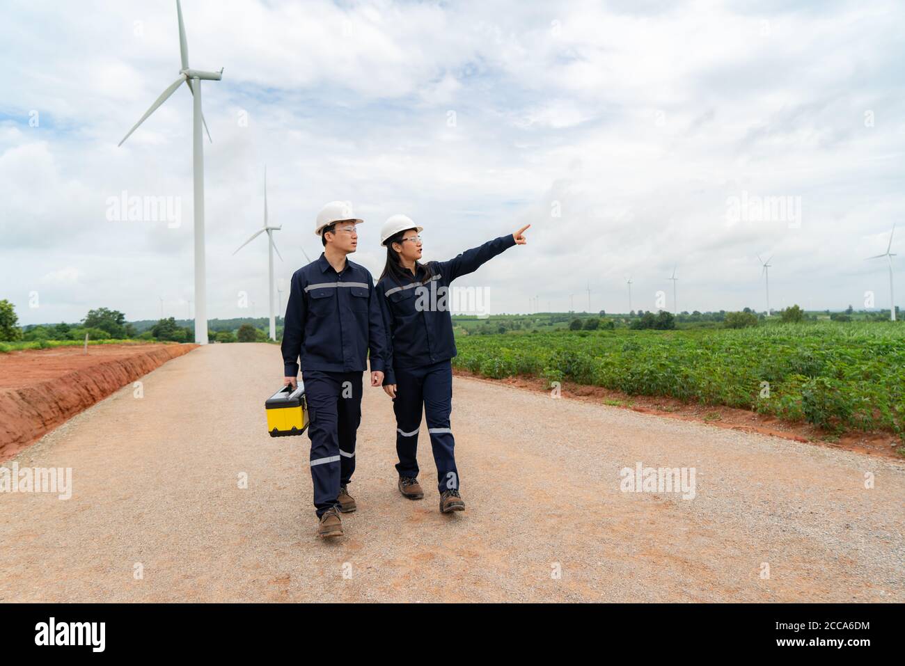Uomo e donna asiatici ingegneri ispezionati preparazione e controllo dei progressi di una turbina eolica con sicurezza in un parco eolico in Thailandia. Foto Stock