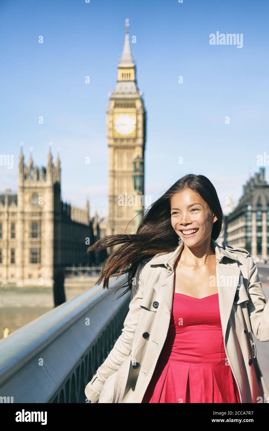 Londra città viaggio in Europa donna turistica a piedi su Westminster Bride al Big ben. Ragazza sorridente asiatica felice che indossa trench di moda e abito rosso Foto Stock