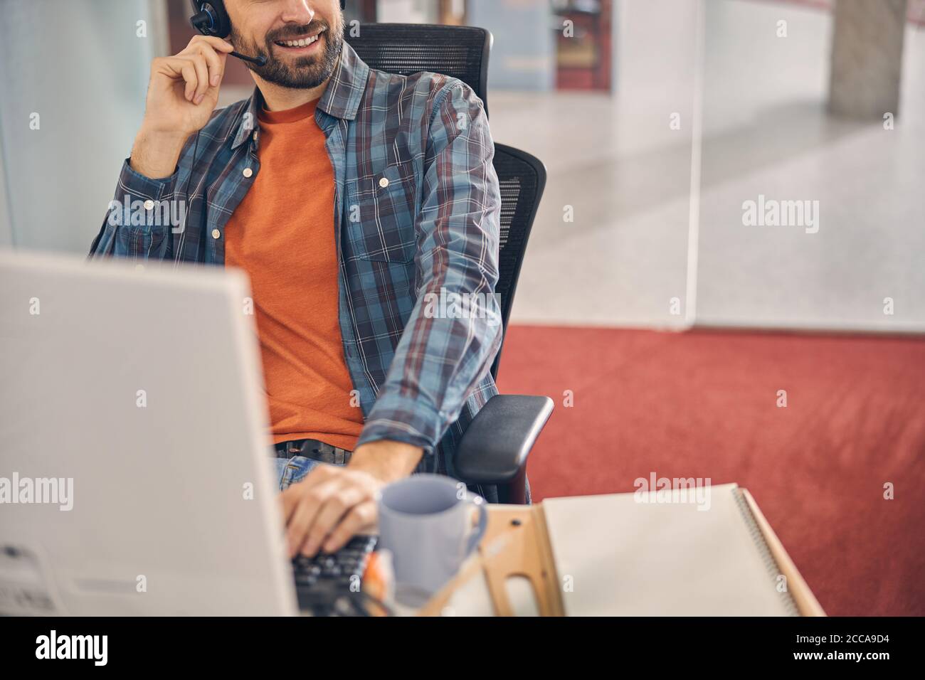 Operatore del servizio clienti maschile che lavora in ufficio Foto Stock