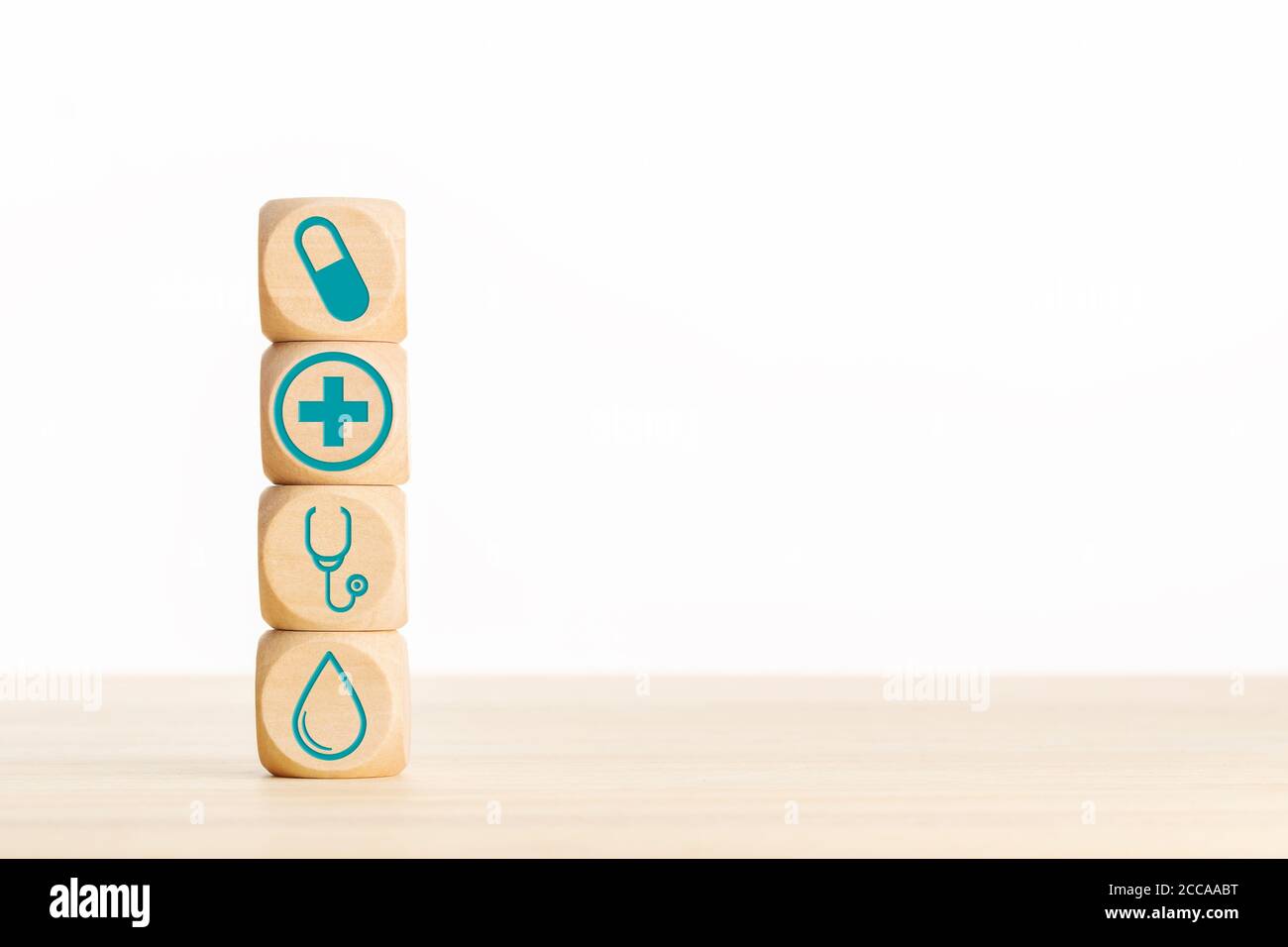 Concetto di medicina o di assistenza sanitaria. Blocchi di legno con icona medica sul tavolo. Spazio di copia Foto Stock