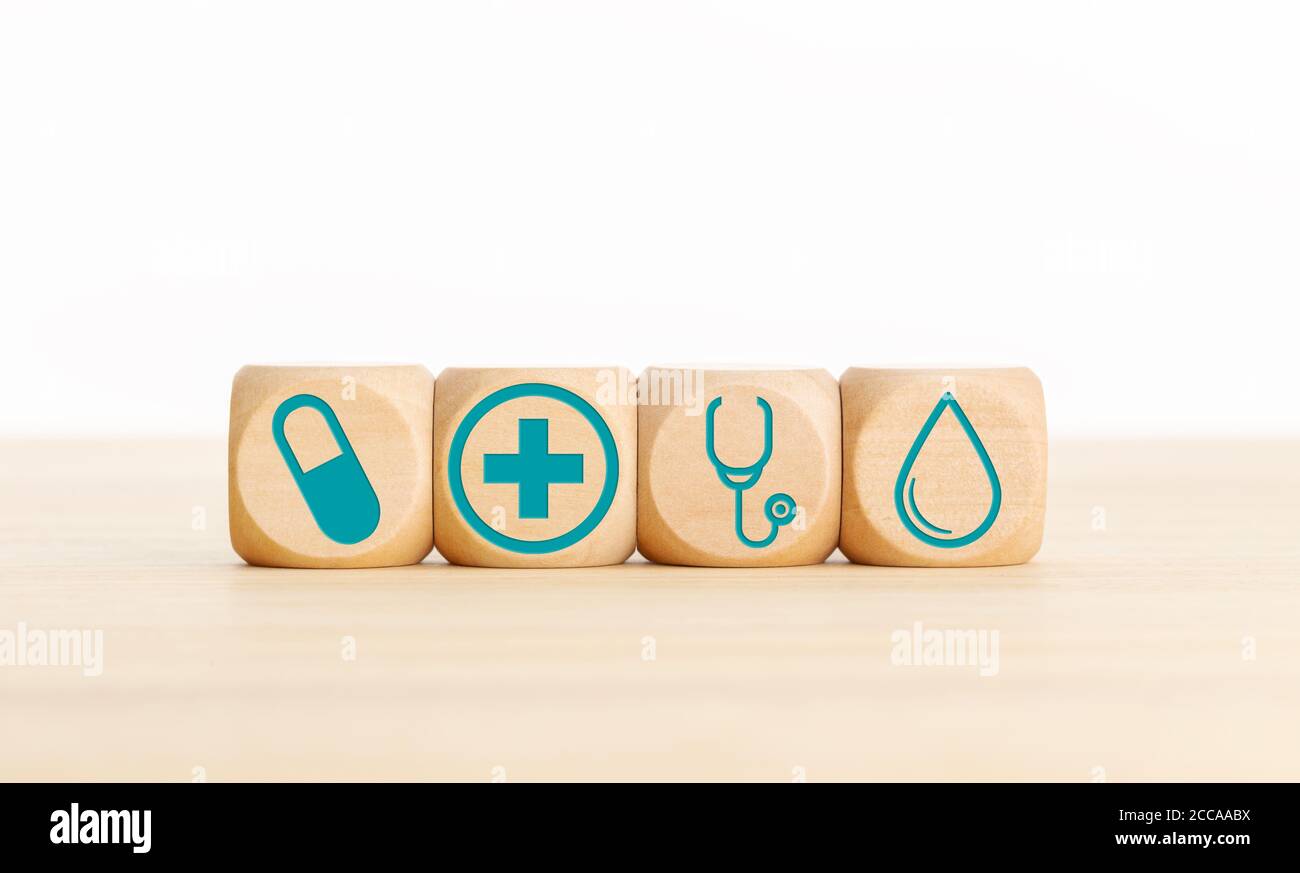 Concetto di medicina o di assistenza sanitaria. Blocchi di legno con icona medica sul tavolo. Spazio di copia Foto Stock