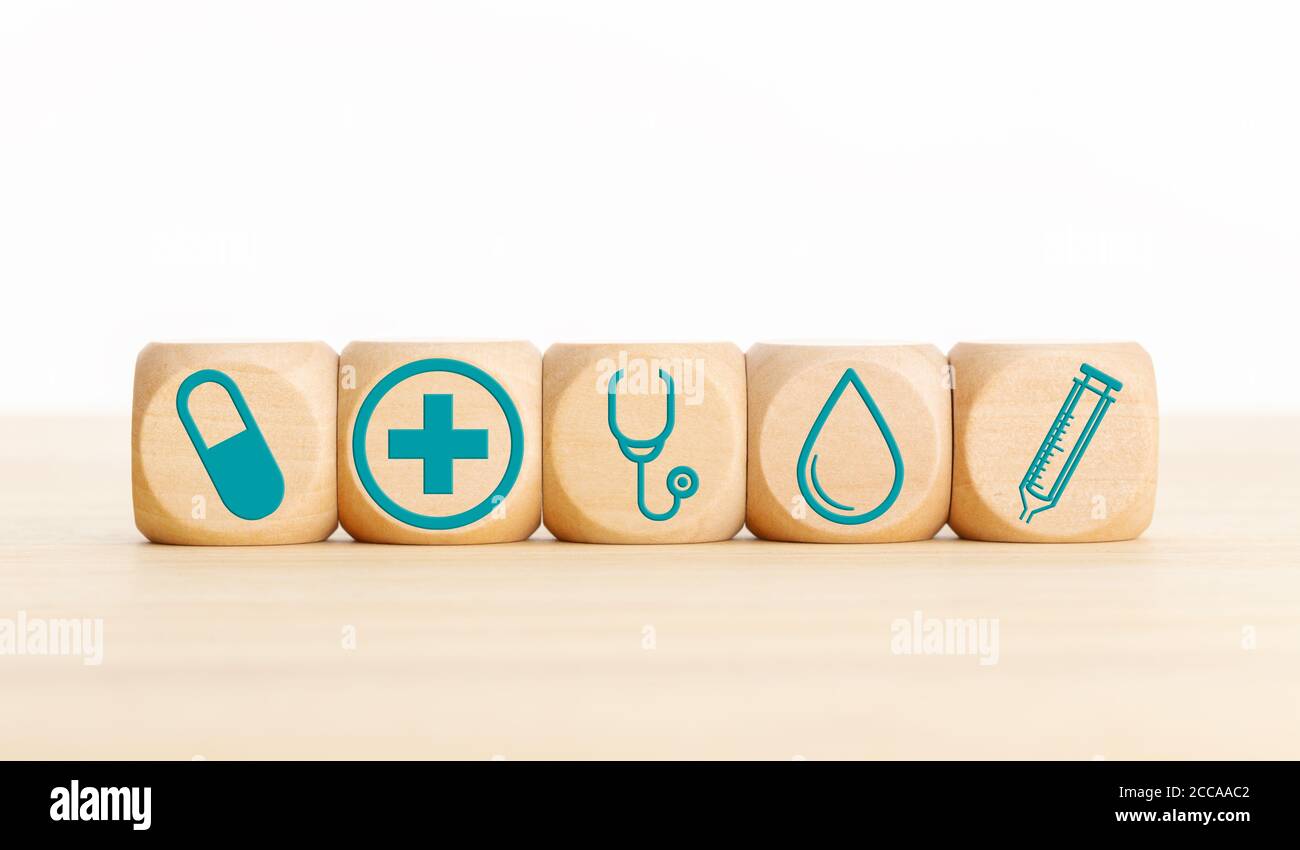 Concetto di medicina o di assistenza sanitaria. Blocchi di legno con icona medica sul tavolo. Spazio di copia Foto Stock