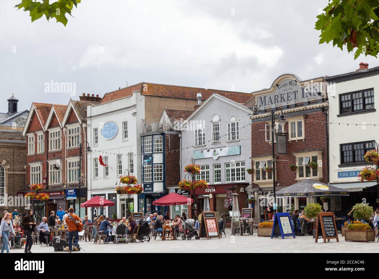 Le persone che gustano un drink all'aperto nella piazza del mercato di Salisbury, Wiltshire, Inghilterra Foto Stock