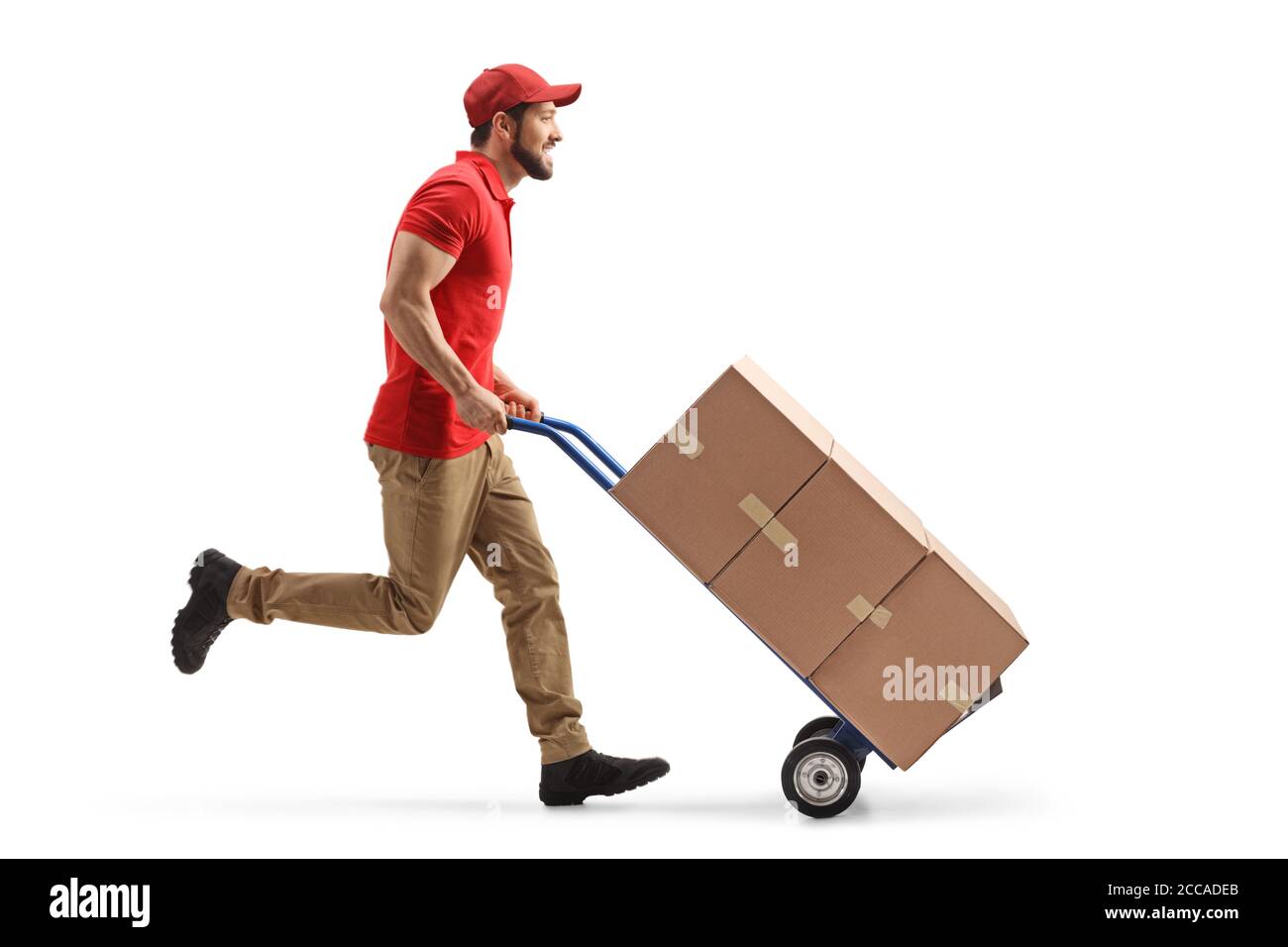 Foto di profilo a lunghezza intera di un lavoratore maschile che esegue con scatole su un carrello a mano isolate su sfondo bianco Foto Stock