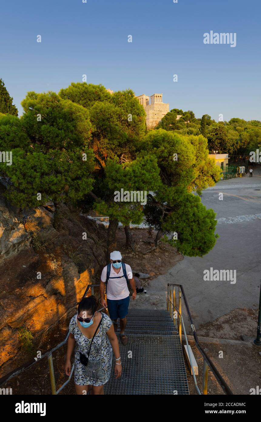 ATENE, GRECIA - 19 agosto 2020 - un paio di turisti che indossano maschere per evitare la diffusione della pandemia COVID-19 salire le scale per Aeropagus Foto Stock