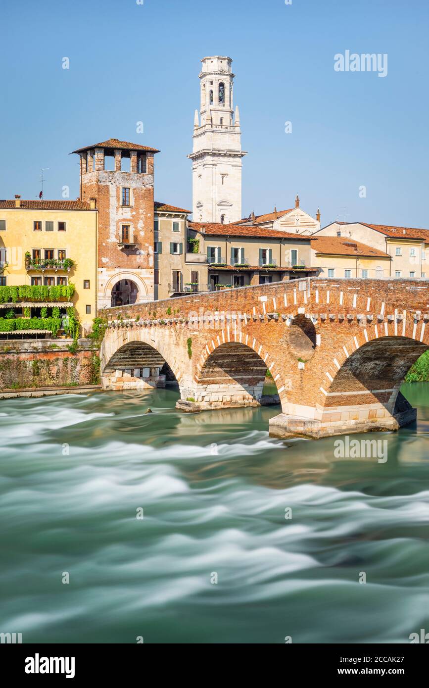 Il ponte romano ad arco di pietra sul fiume Adige con il panorama del centro storico di Verona al sole del mattino, Veneto, Italia Foto Stock