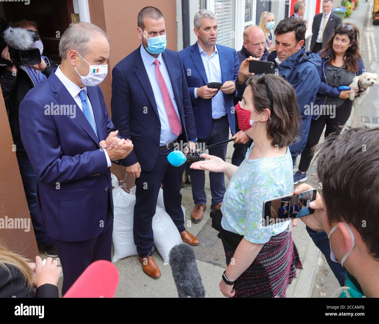 Un Taoiseach Micheal Martin chiacchiera con la gente del posto su Bridge Street mentre visita le case e le aziende danneggiate dall'alluvione di Skibbereen la mattina dopo un'alluvione ha causato danni ingenti a un certo numero di locali nella popolare cittadina turistica irlandese. Foto Stock