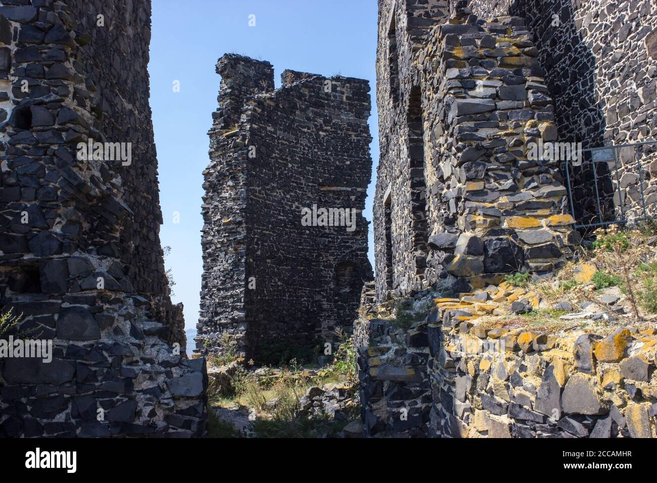 Ruines del castello di Hazmburk in cima alla cima della catena montuosa di ceske stredohori. Vista sulla torre bianca e sulle rovine delle mura. Foto Stock