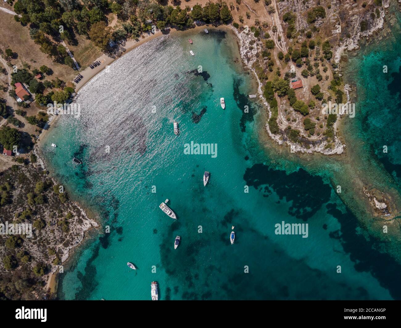 Paesaggio mediterraneo greco costiero drone girato con barche ormeggiate tempo libero. Vista dall'alto della penisola di Sithonia Chalkidiki sopra il litorale. Foto Stock