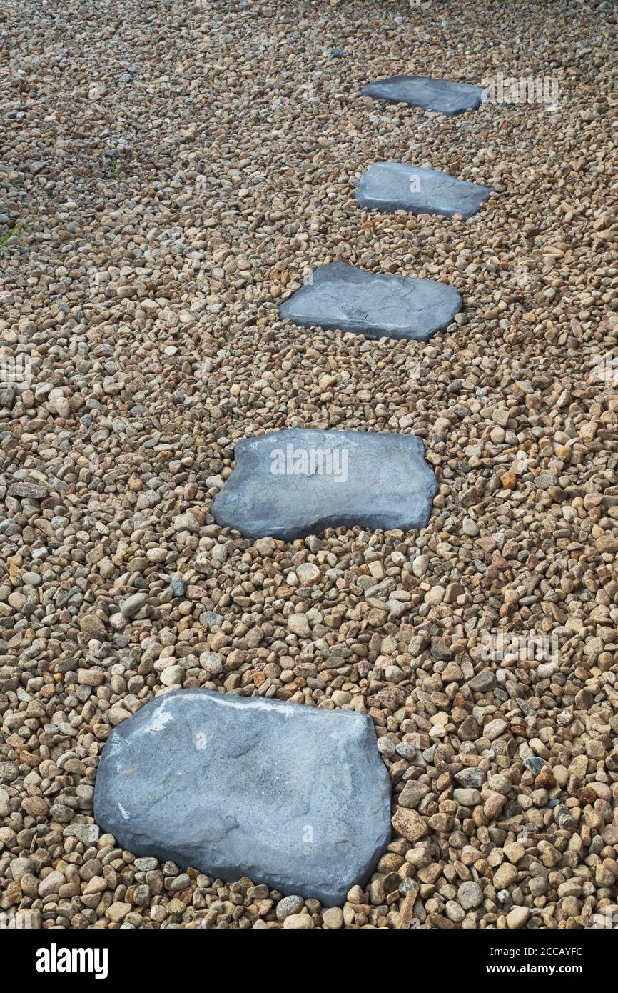 Pietre grigie percorso in letto di rocce in giardino residenziale baclyard. Foto Stock