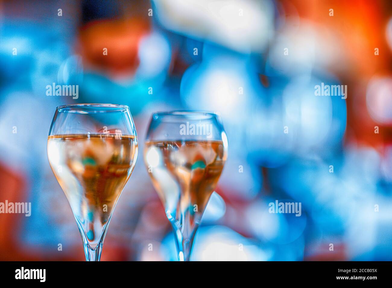 Giovane barista italiano con maschera facciale versando vino bianco in due bicchieri per celebrion Foto Stock