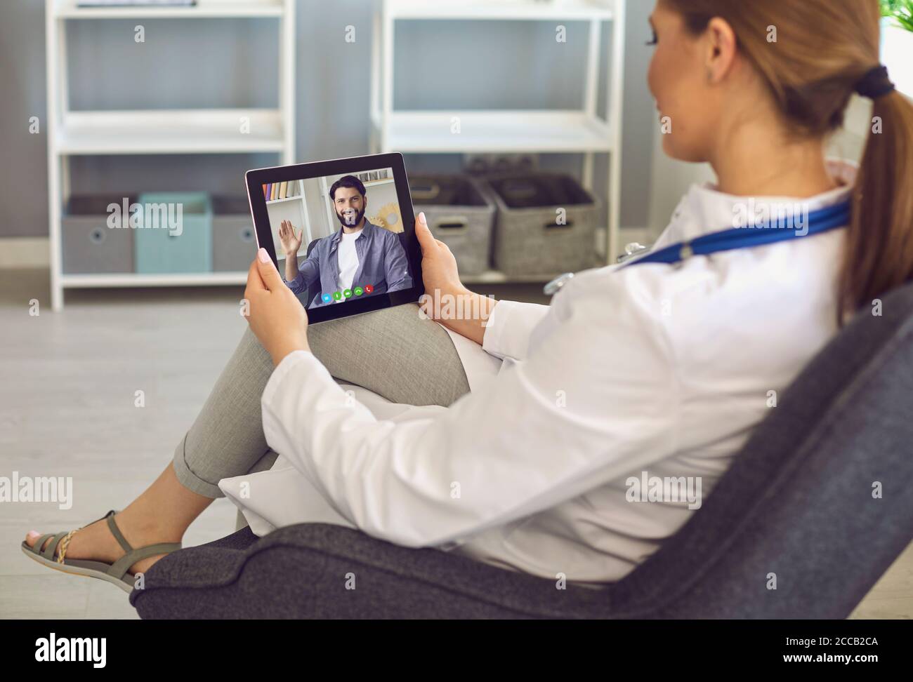 Donna medico saluto studente durante la lezione online sulla schermata clipboard Foto Stock