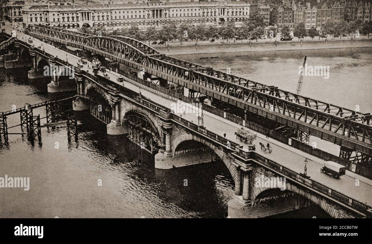 Waterloo Bridge attraversa il Tamigi tra Blackfriars Bridge e Hungerford Bridge, a Londra. Per motivi di sicurezza, il London County Council decise di demolire il ponte e di sostituirlo con una nuova struttura progettata da Sir Giles Gilbert Scott negli anni trenta. Il progetto è stato messo in sospeso a causa della seconda guerra mondiale, ma è stato installato un ponte di acciaio temporaneo. Foto Stock